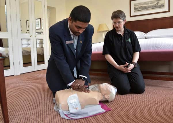 Chandra Moorthy of the Tickled Trout hotel learns CPR. The hotel has recently installed a defibrillator