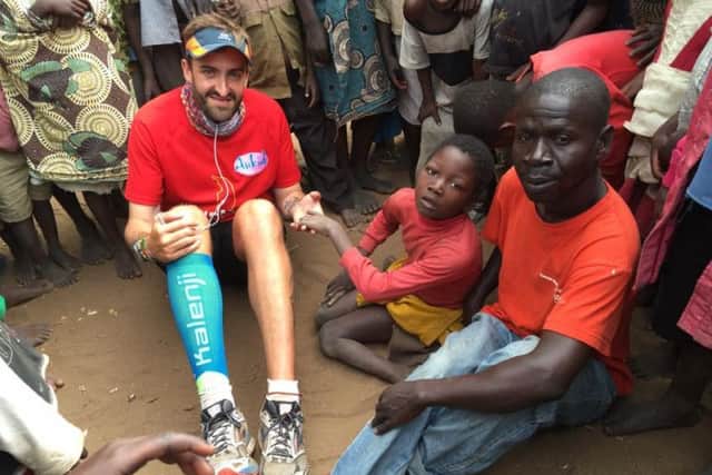 Brendan Rendall with 12-year-old Ganizani who could not walk. Brendan donated a wheelchair via FOMO