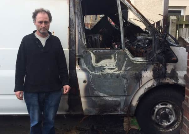 Gary Deegan standing next to his torched transit van.
