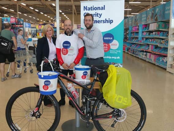John Gore (centre) who is cycling from Leyland to Plymouth and stopping off at Tesco stores