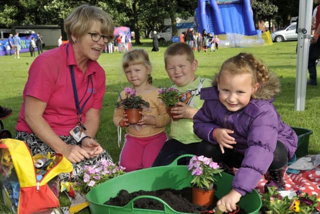 Mary Johnson, outreach worker with Patrycja Dziwisiwski, four, Marcin Dziwisiwski, six and Lola Munro, five planting flowers they can take home at the Ribbleton Park It event