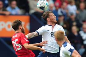 Joe Garner challenges Fulham's Michael Madl at Deepdale