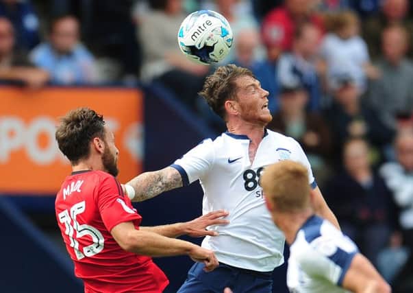 Joe Garner challenges Fulham's Michael Madl at Deepdale