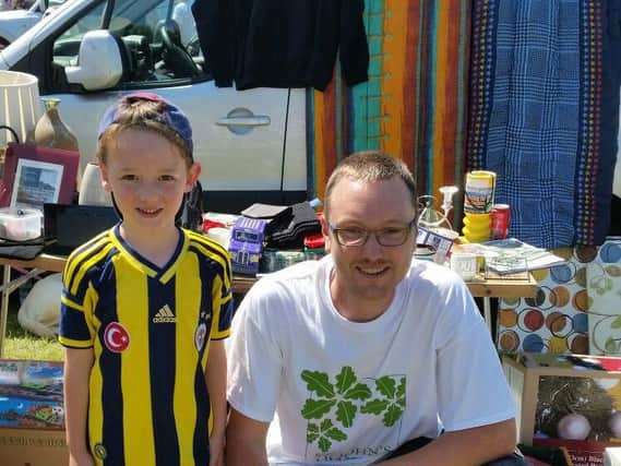 Dave Nichols at a car boot sale with helper Jake Fishwick who donated some of his old toys and books to the stall