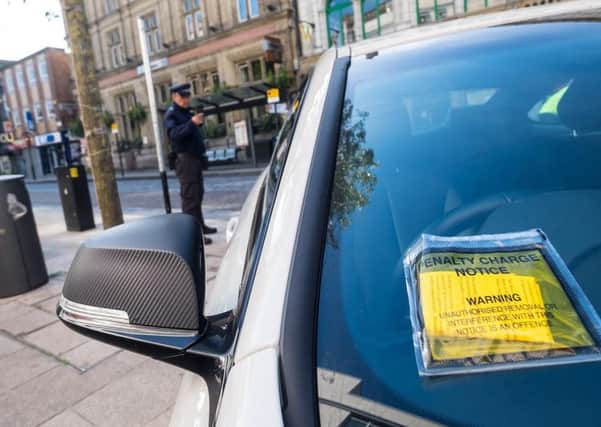 TICKETS, PLEASE: A traffic warden at work in the shared space zone and, below, illegally parked cars