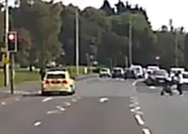 A police car filmed seemingly driving through a red light