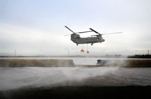 An RAF Chinook helicopter is deployed to help fill a hole in the flood defences of the River Douglas near Croston