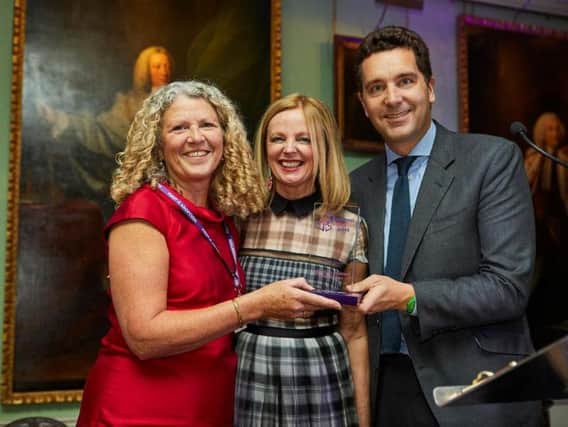 Delyth Evans receives her award from Claire Grogan and Edward Timpson
