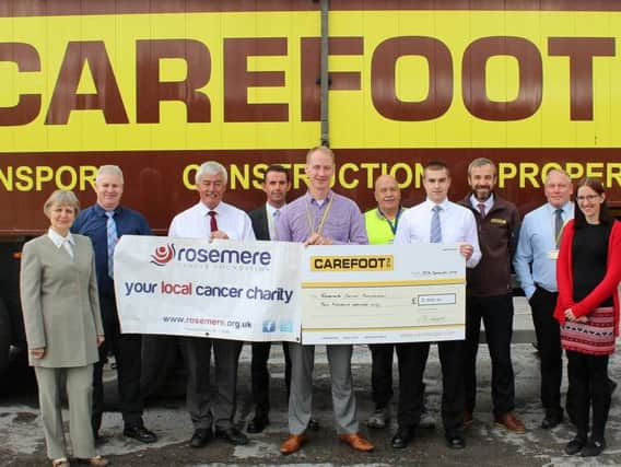 Some of Carefoot PLCs dragon boat crew and colleagues, who helped with sponsorship, present their donation to Rosemeres head of fundraising Dan Hill, fifth from the left