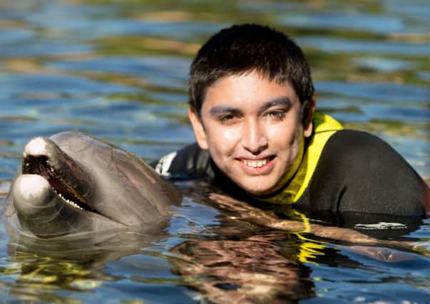 Jaize Farid, 14, from Preston, enjoys a swim with a dolphin during the Dreamflight visit to Discovery Cove in Orlando, Florida. PRESS ASSOCIATION Photo. Picture date: Sunday October 23, 2016. See PA story CHARITY Dreamflight. Photo credit should read: Steve Parsons/PA Wire