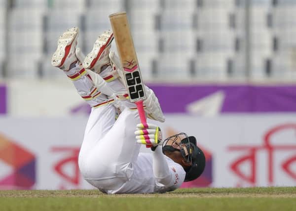 Bangladesh's captain Mushfiqur Rahim falls down on the ground after the ball hits on his helmet