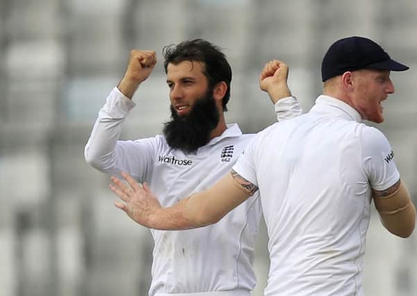 England's Moeen Ali, left, celebrates with teammate Ben Stokes the dismissal of Bangladesh's Mominul Haque