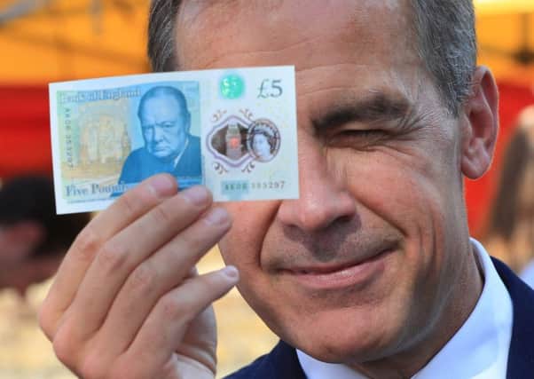 Bank of England Governor Mark Carney holds a new plastic Â£5 note  but one reader is unhappy with Elizabeth Fry being replaced
