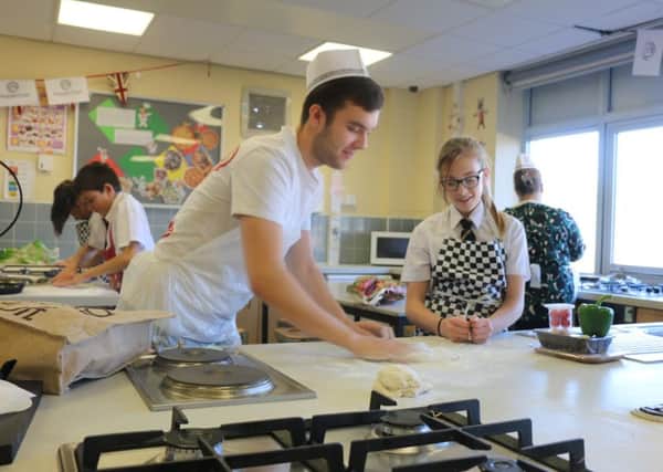 Oliver Jefferson from Pizza Express Lytham shows pupils at Penwortham Priory Academy how to make a pizza