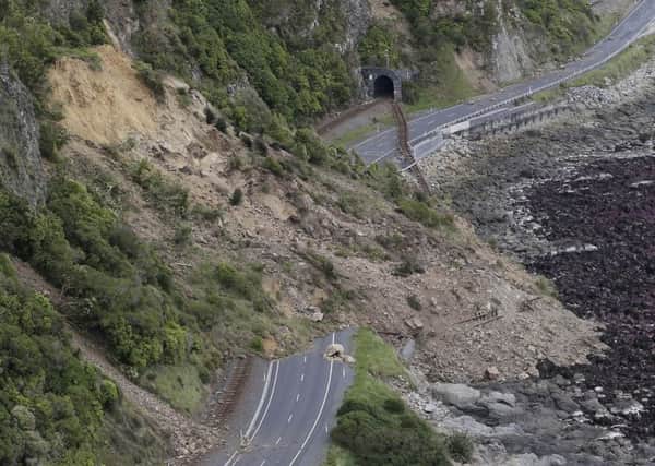 A landslide blocks State Highway One and the main railway line north of Kaikoura following an earthquake in New Zealand, Monday, Nov. 14, 2016. A powerful earthquake that rocked New Zealand on Monday triggered landslides and a small tsunami, cracked apart roads and homes and left two people dead, but largely spared the country the devastation it saw five years ago when a deadly earthquake struck the same region. (Mark Mitchell/New Zealand Herald/Pool via AP)
