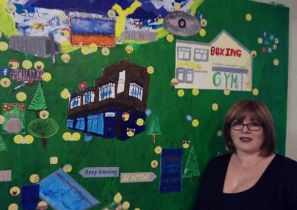 Robyn Thomas from Stanley's Youth and Community Centre with a mural created by youngsters at the centre.