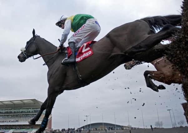 2014 Grand National winner Many Clouds ridden by Leighton Aspell clears the last fence on the way to winning the Betfred Chase at Aintree