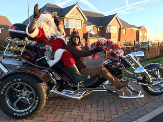 Santa Claus on his motorbike being driven around by his reindeer
