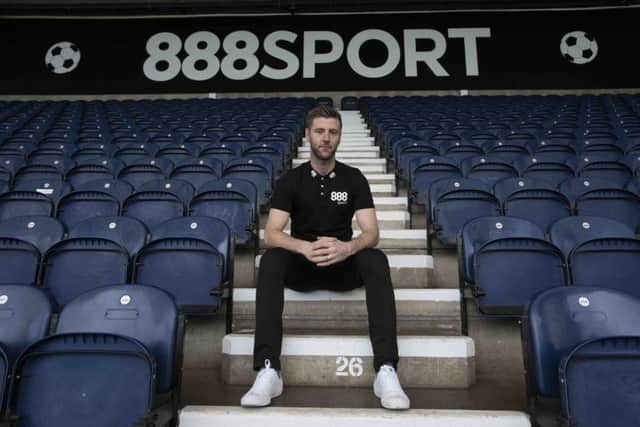 PNE midfielder Paul Gallagher in front of the new advertising boards at Deepdale