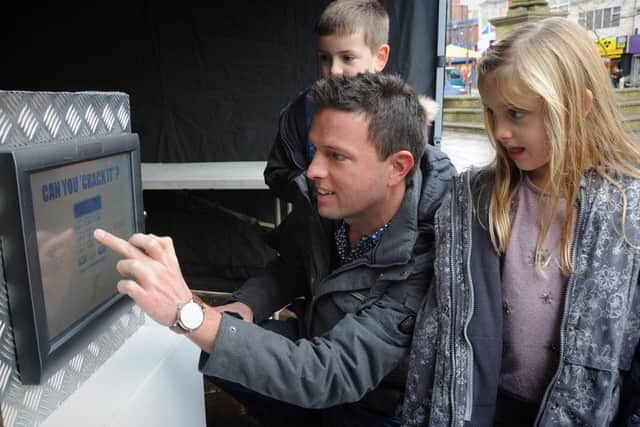 Preston shoppers had the chance of a bumper Christmas by attempting to crack the code of the 'City Safe' containing Â£10,000.
Isla and Lewis Taylor watch dad Chris in action, which resulted in a runners-up prize of a month's free journeys with South Ribble Travel.  PIC BY ROB LOCK
10-12-2016