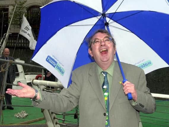 Ian McCaskill shelters from the rain at the launch of the Water Month 2000 in the West India Docks, London.