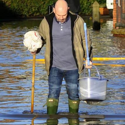 The Lancashire village of Croston was one of the worst affected in the area by the Boxing Day floods. An ever-optimistic resident with his mop and bucket.