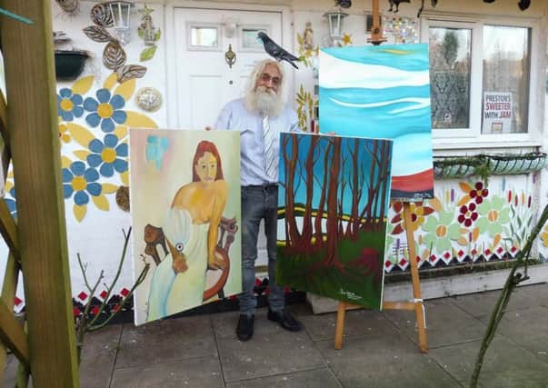 Jam Imani Rad with paintings he is auctioning for the children of Aleppo