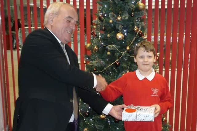 Kiyan Brundrett  receiving his iPad from Jim Brotherston, operations manager at St George's Shopping Centre in Preston