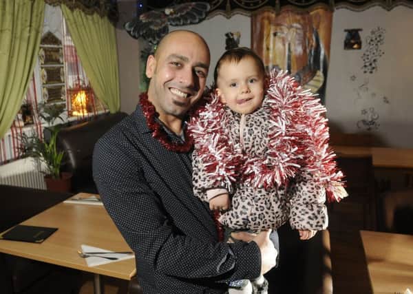 Walaa Hassan from restaurant Lola on London Road is offering free food and drink to those in need on Christmas Day.  He is pictured with two-year-old daughter Laila Hassan.