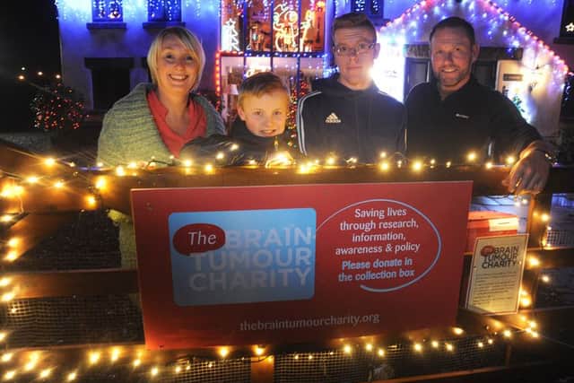 Ann Marie Woodcock, of Brindle Road Bamber Bridge, has added a collection box for the Brain Tumour Charity to the family's Christmas lights-decorated home. Ann Marie's first husband Lee died of the disease at the age of 42.
Pictured with the box are L-R: Ann Marie, son Danny, stepson Daniel Molloy and husband Michael Molloy.  PIC BY ROB LOCK
2-12-2016