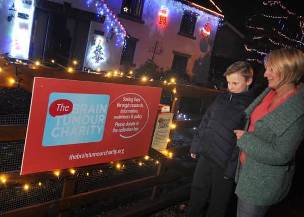 Ann Marie Woodcock, of Brindle Road Bamber Bridge, has added a collection box for the Brain Tumour Charity to the family's Christmas lights-decorated home. Ann Marie's first husband Lee died of the disease at the age of 42.
Pictured with the box are Ann Marie and son Danny.  PIC BY ROB LOCK
2-12-2016