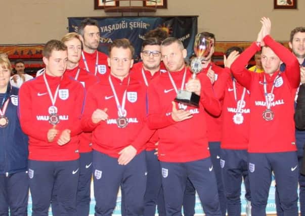 Futsal player Steve Daley (holding trophy) is congratulated by his team-mates after his record-breaking England feats at the European Championships, in Turkey