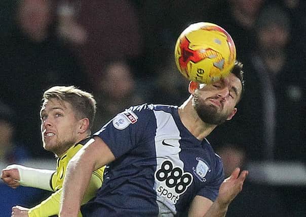 Bailey Wright challenges in the air with Burton striker Jamie Ward