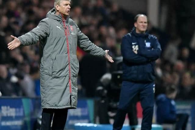 Managers Arsene Wenger and Simon Grayson look on at Deepdale.