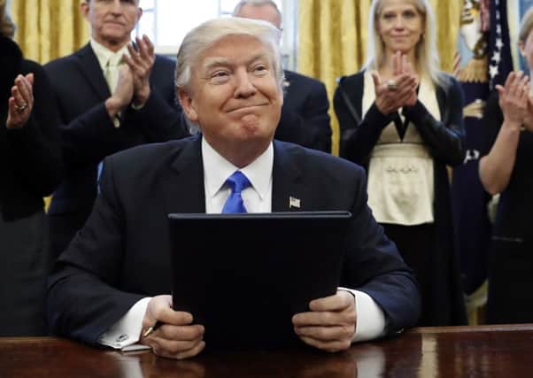 President Donald Trump smiles after signing three executive actions in the Oval Office, Saturday, Jan. 28, 2017 in Washington. (AP Photo/Alex Brandon)
