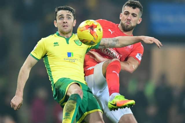 Huddersfield Town's Tommy Smith vies for possession with Norwich City's Robbie Brady