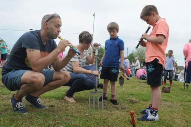 Families and friends take part in the third annual Aspull Worm Charming Championships, where teams try vibration techniques to get worms out of the ground, held at St Elizabeth's Parish Hall field, Aspull.