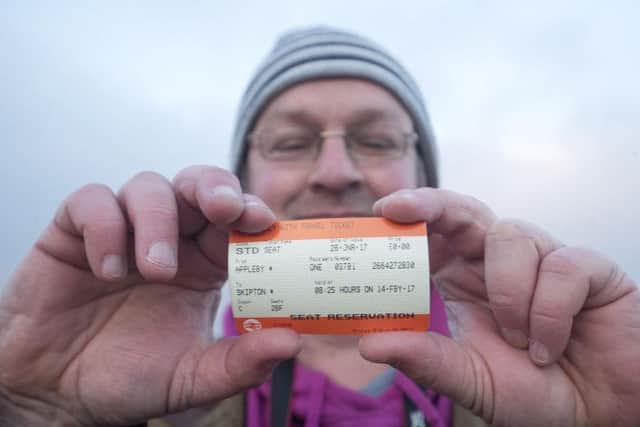 A man holds his ticket for the Tornado locomotive at Appleby station
