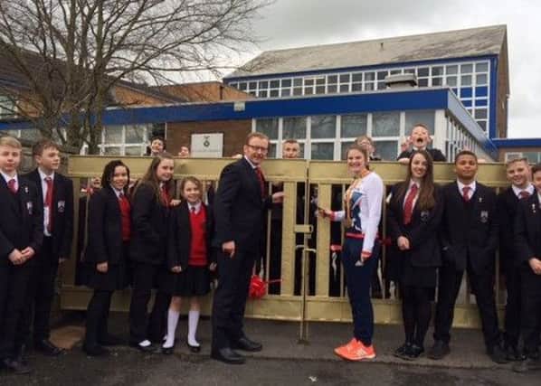 Gold Paralympian medalist Steph Slater pictured at the 'golden gates' of her former high school, St Cecilia's, Longridge with headteacher, Ivan Catlow and current pupils.