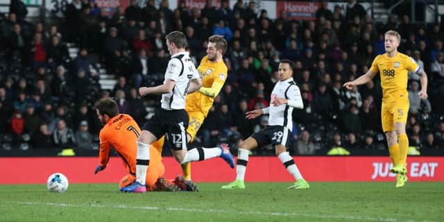 Preston North End's Tom Barkhuizen beats Derby County's goalkeeper Scott Carson to the ball and scores his side's equalising goal.