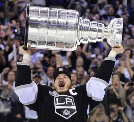 Los Angeles Kings captain Dustin Brown hoists the Stanley Cup after the Kings beat the New Jersey Devils 6-1 during Game 6 of the NHL hockey Stanley Cup finals, Monday, June 11, 2012, in Los Angeles. (AP Photo/Mark J. Terrill)