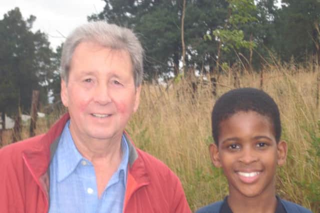 Norman Yates, trustee of Partners in Education with a young boy who is sponsored through the programme