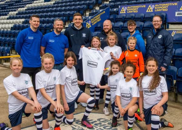 Preston North End striker Jordan Hugill presents Preston City Girls' Under-11s with their new kit as part of Wickes' Kits for Kids campaign.