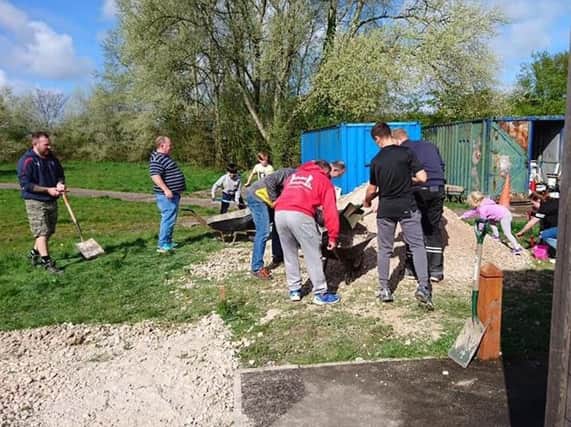 Volunteers at Leyland Warriors pitch in to shift the fifteen tons of gravel donated by C&W Berry to help build a car park