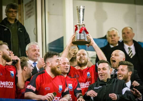 Bamber Bridge captain Matt Lawlor lifts the NPL League Cup after their 2-1 win over Grantham Town (photo: Ruth Hornby)