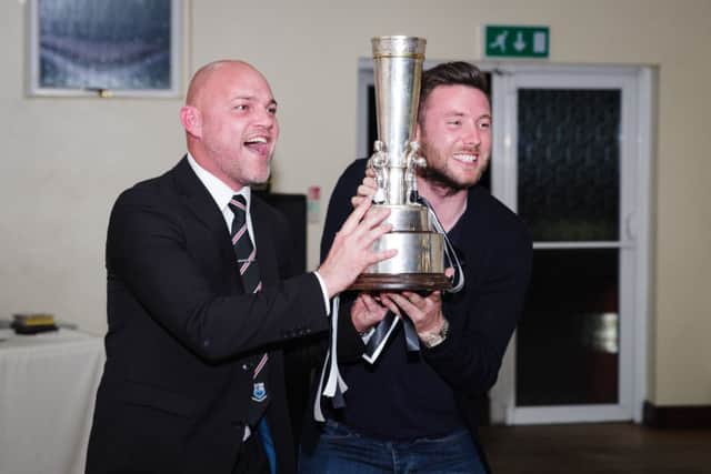 Bamber Bridge boss Neil Reynolds lifts the League Cup alongside his assistant Simon Wiles at the club's end of season presentation evening