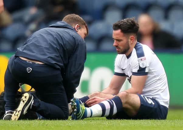 Greg Cunningham is attended to by PNE physio Matt Jackson after fracturing his leg against Norwich