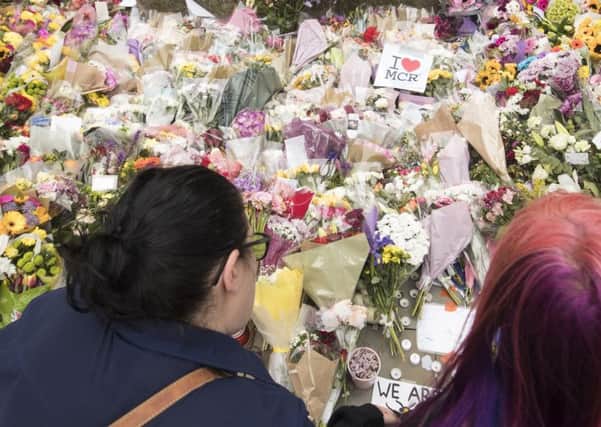 People view floral tributes in St Ann's Square, Manchester, close to the Manchester Arena where a suicide bomber killed 22 people Photo: Danny Lawson/PA Wire