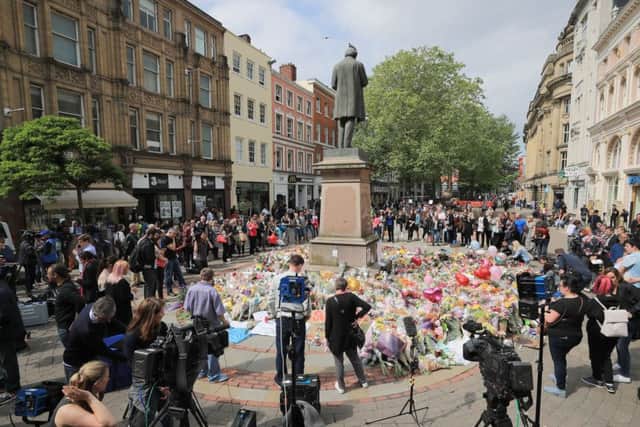 People look at flowers in St. Ann's Square, close to the Manchester Arena where a suicide bomber killed 22 people leaving a pop concert at the venue on Monday night. PRESS ASSOCIATION Photo. Picture date: Wednesday May 24, 2017. The attack killed 22 people, including children, and injured dozens more in the worst terrorist incident to hit Britain since the July 7 atrocities. See PA story POLICE Explosion. Photo credit should read: Peter Byrne/PA Wire