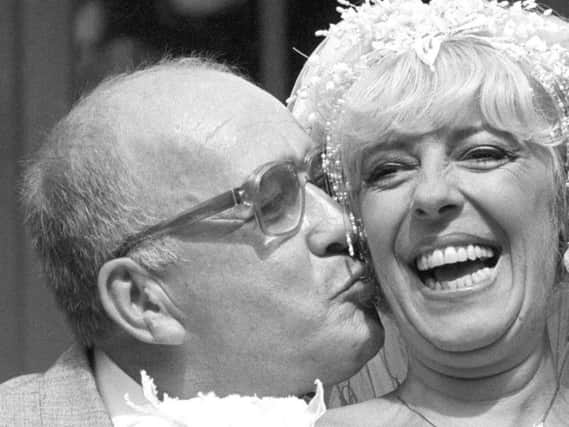 Coronation Street barmaid Bet Lynch (actress Julie Goodyear) getting a kiss from television groom Alec Gilroy (actor Roy Barraclough)